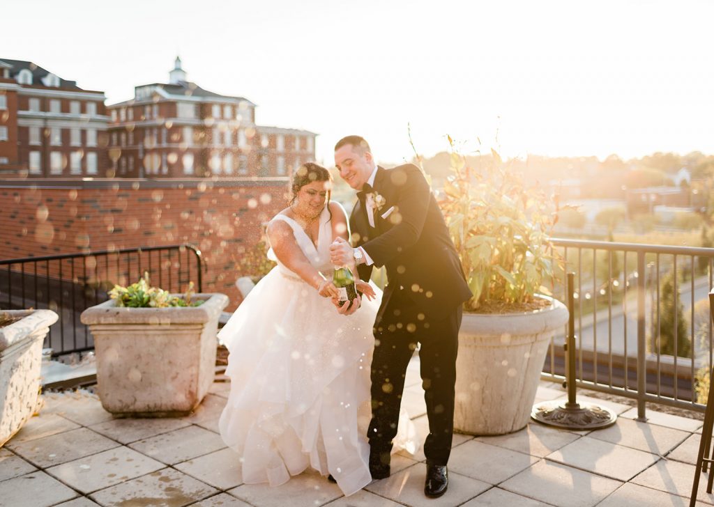 A wedding couple is opening a bottle of champaign at the Palladium, one of the wedding venues St. Louis offers.