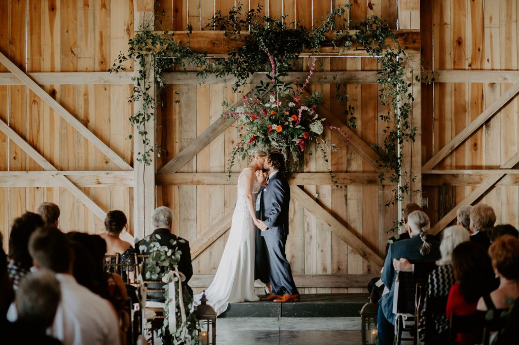 A wedding couple is kissing each other at the altar at the Old School Farm in Nashville.