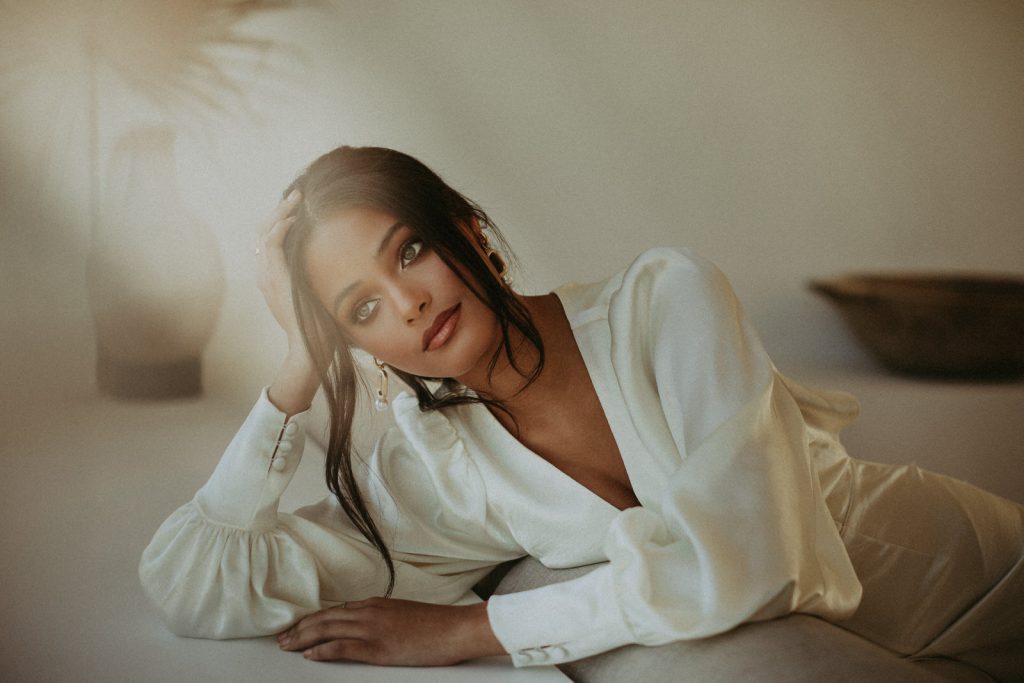 A woman is leaning on a piece of furniture.