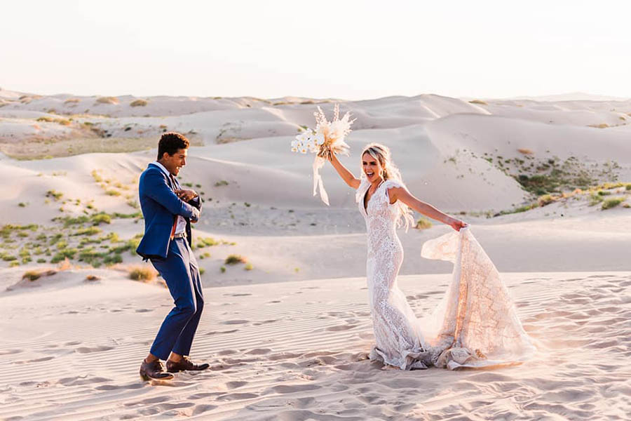 A wedding couple is dancing on the Sand Dunes in Utah, one of the wedding venues in Utah.