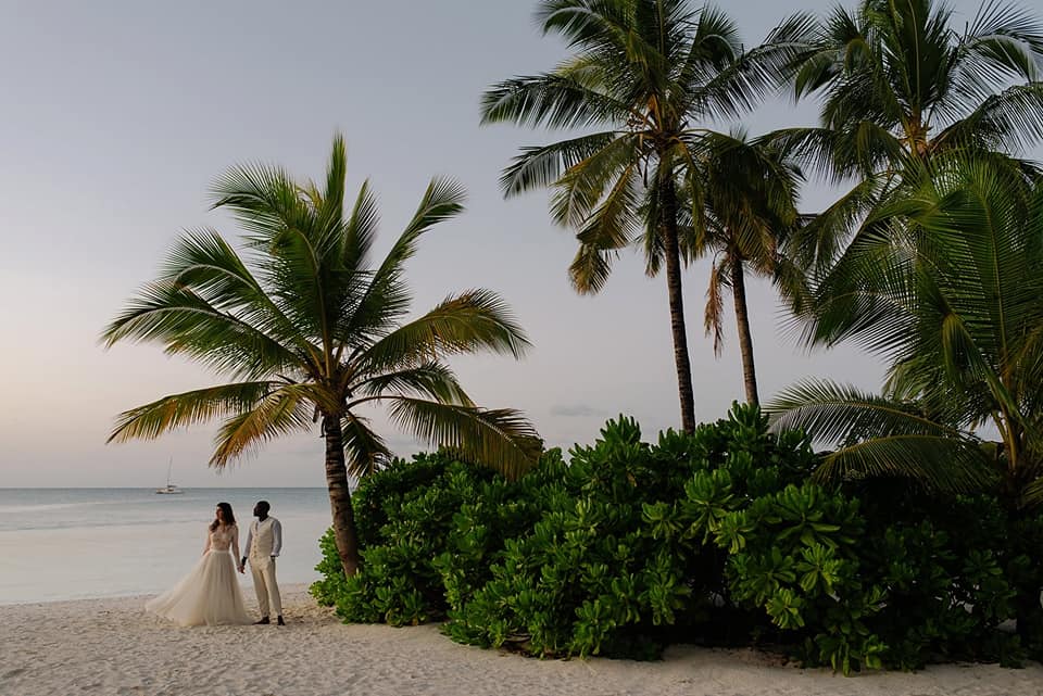 A wedding couple is standing on the beach in Zanzibar.