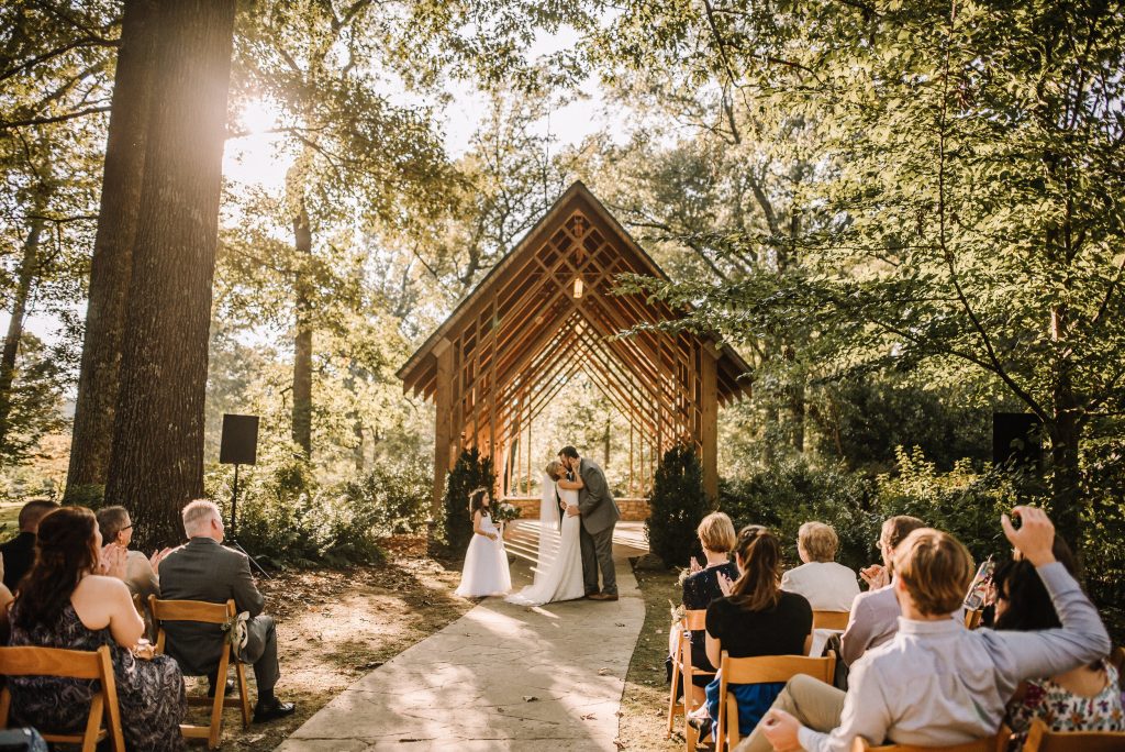 A wedding coupls is kissing each other at the Memphis Botanic Garden, one of the wedding venues Memphis TN offers.