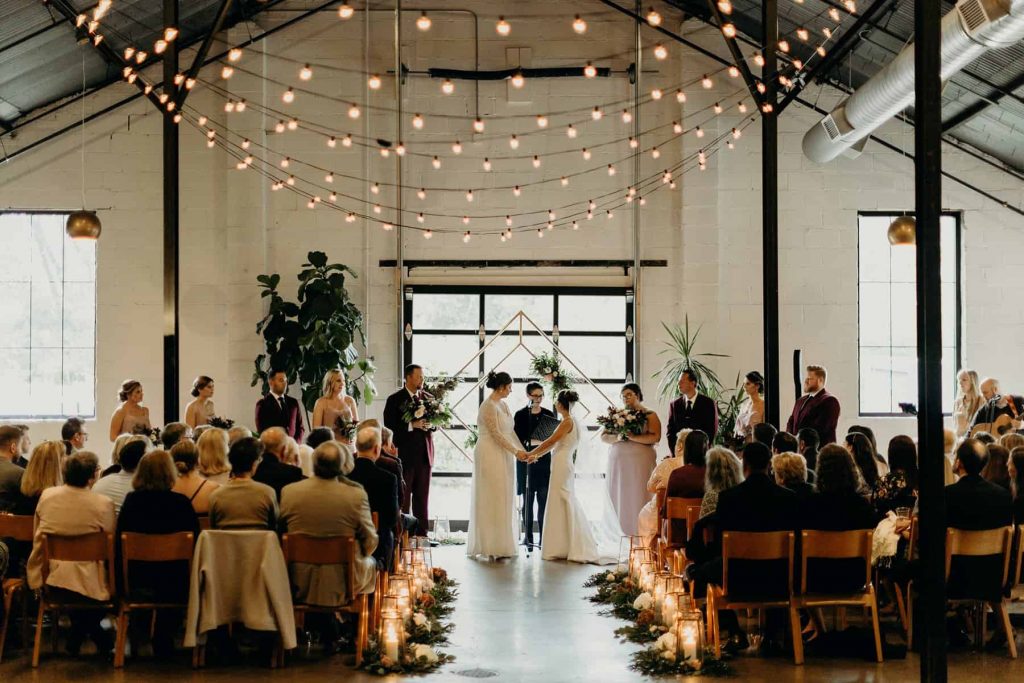 A wedding couple is standing at the altar at PAIKKA, one of the Minnesota wedding venues.