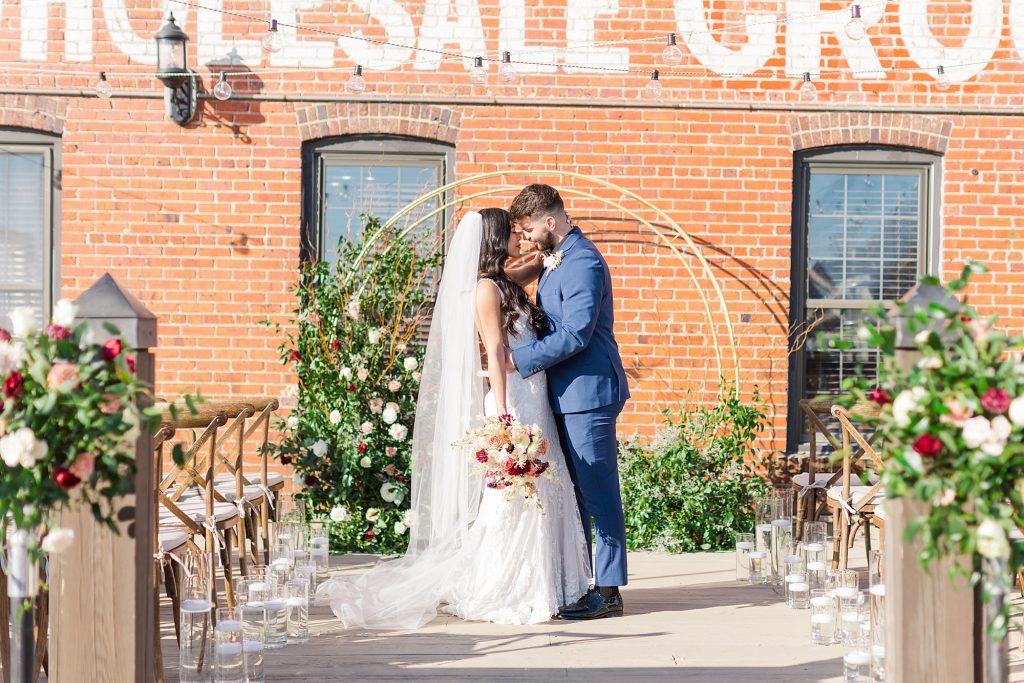 A wedding couple is holding each other and standing at the altar at the River Room, one of the wedding venues Wilmington NC offers.