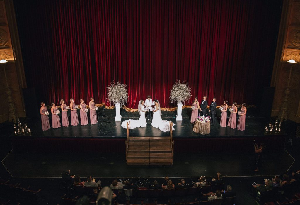A wedding couple is getting married on stage of the Detroit Opera House, one of the Detroit wedding venues.