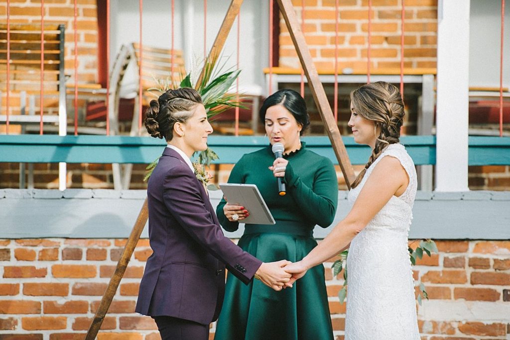A wedding couple is holding hands and getting married at the altar at the CL Space, one of the wedding venues Tampa offers.
