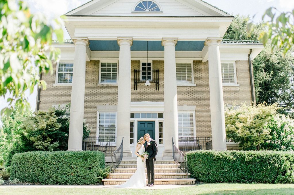 A wedding couple is standing in front of the Venetian Estate, one of the West Virginia wedding venues.