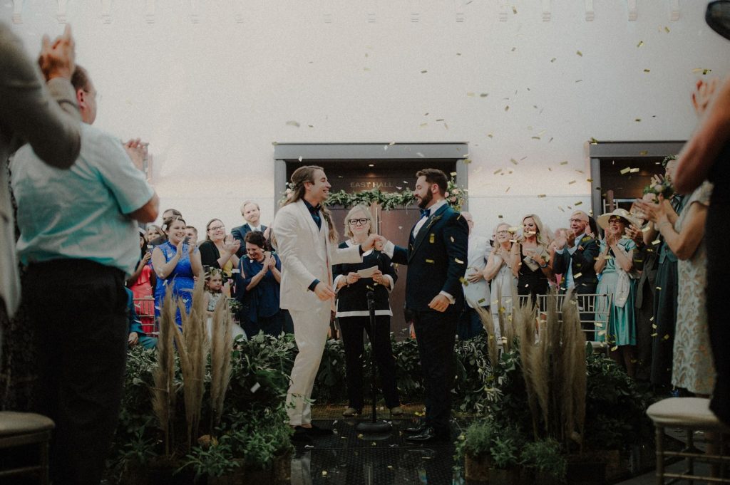 A wedding couple just got married and their guests are applauding and smiling at the Limestone Hall, one for the wedding venues in Kentucky.