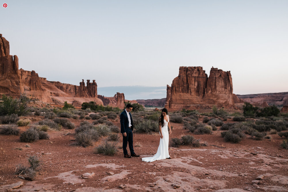 A wedding couple is walking through the Canyonlands National Park in Utah. 
