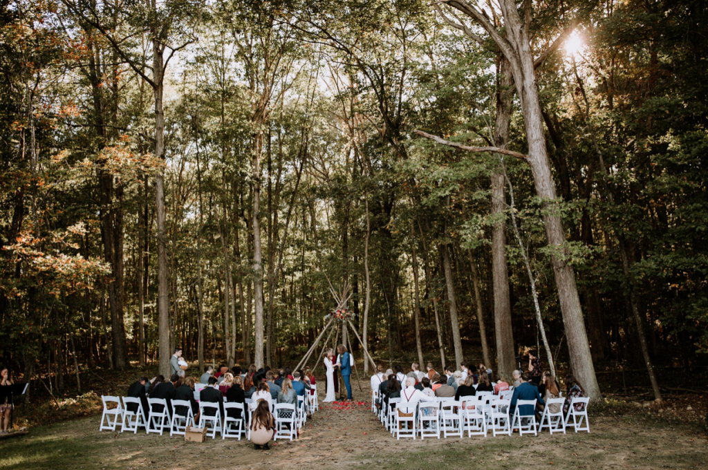 A wedding couple is getting married in a forest at Brenwood Lake Weddings, one of the wedding venues in Virginia.