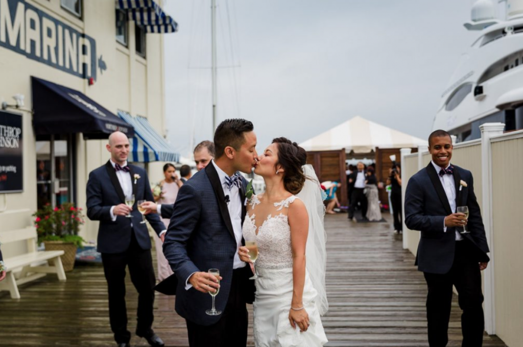 A wedding couple is kissing each other at the regatta Place in Newport, one of the wedding venues in Rhode Island.