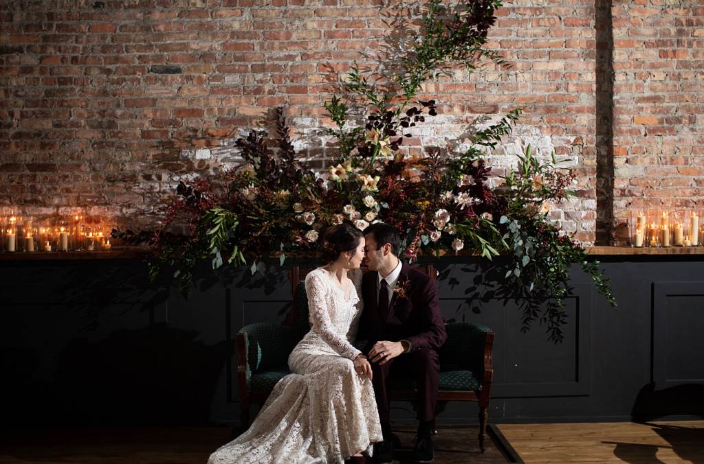 A wedding couple is sitting on a couch at the Mercantile Hall, one of the wedding venues Wisconsin.