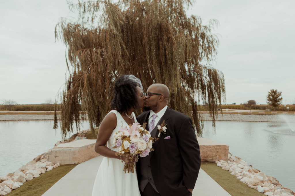 A wedding couple is kissing each other at the Epic Event Center, one of the wedding venues in Iowa.