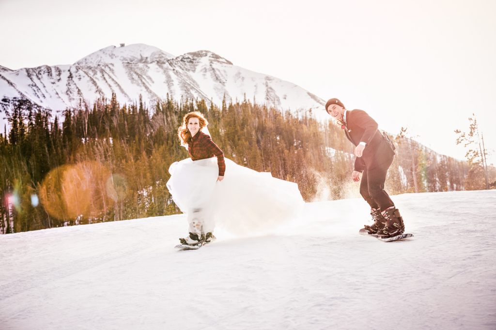 A wedding couple is snowboarding at the Big Sky Resort in Montana.
