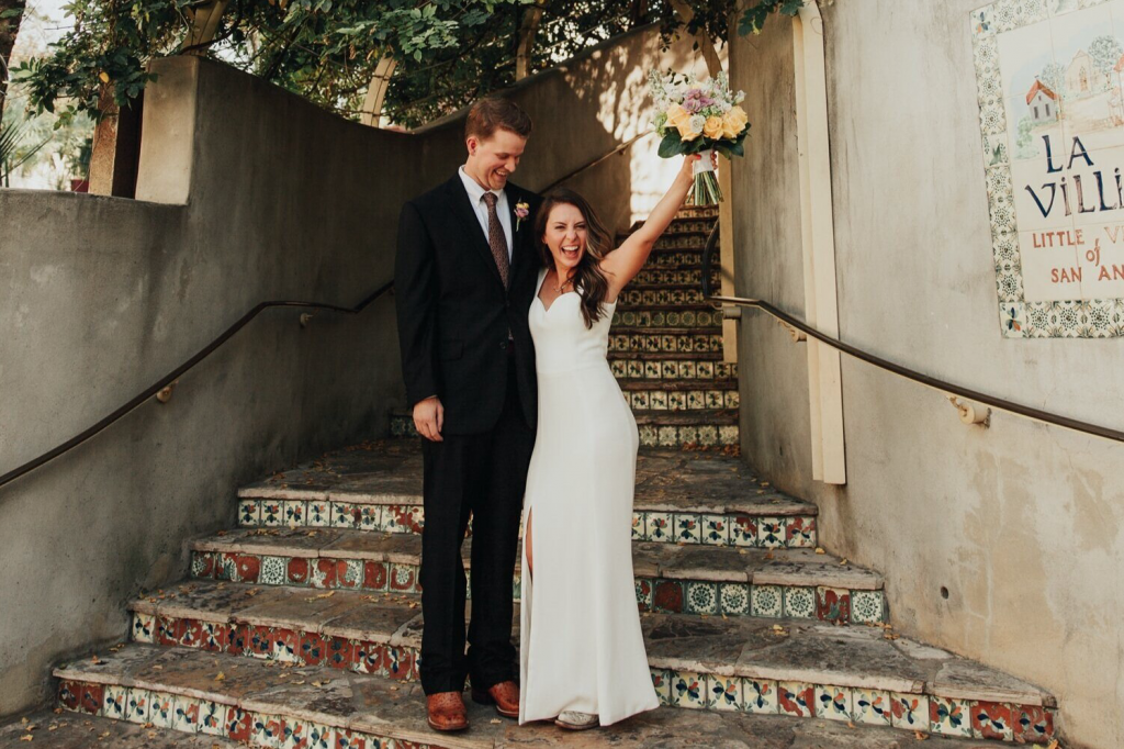 A wedding couple is standing at the stairs of La Villita, one of the wedding venues San Antonio offers.