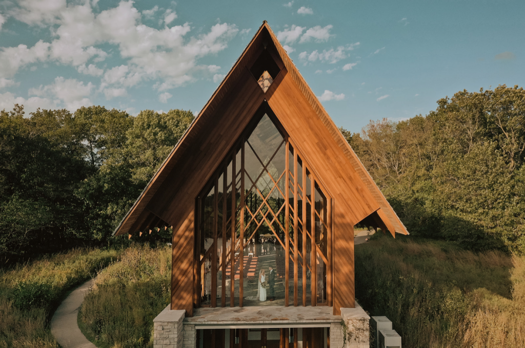 A wedding couple is standing in the Powell Gardens chapel, one of the wedding venues Kansas City offers.
